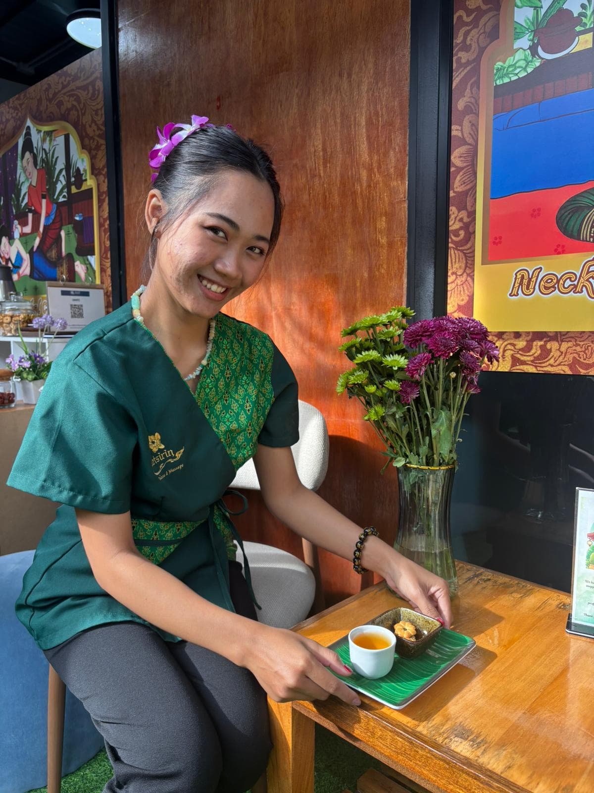 Welcoming staff member serving traditional Thai tea and refreshments at Ketsirin Bang Tao