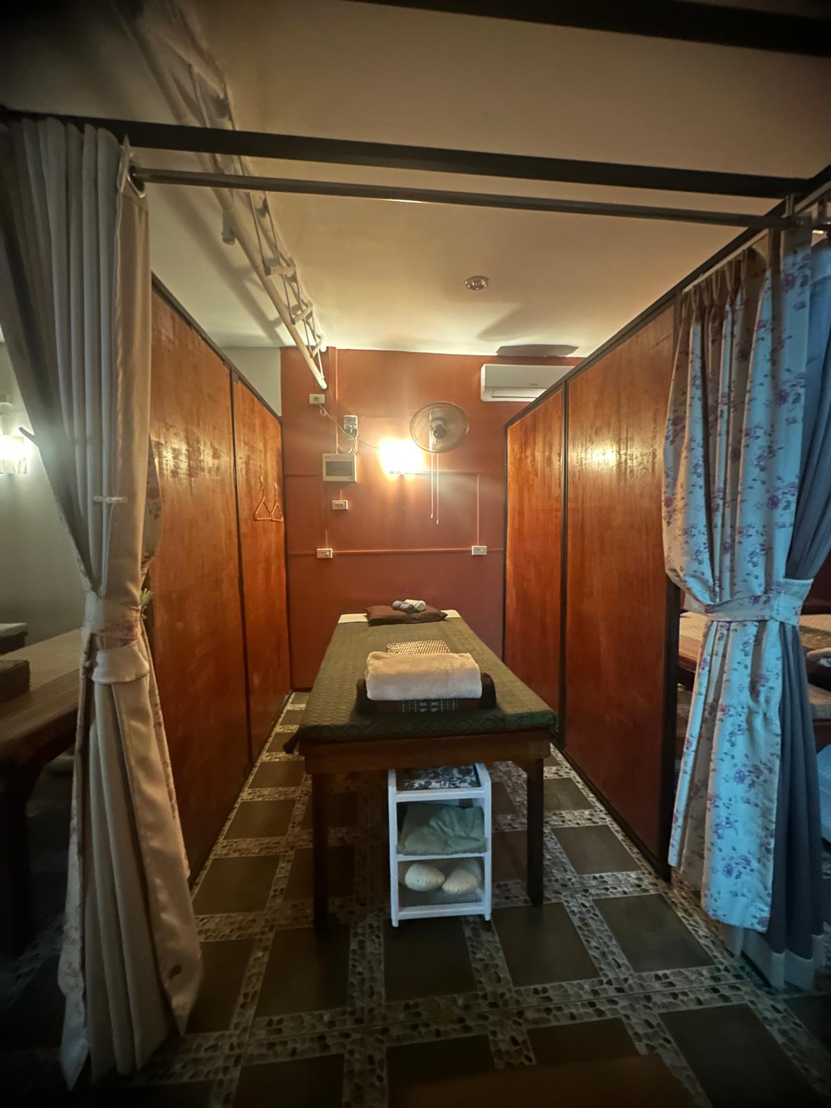 Single treatment room with warm lighting and privacy curtains