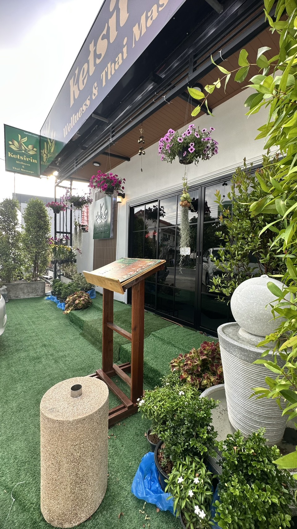 Ketsirin Cherngtalay entrance pathway with menu stand, hanging baskets and tropical plants