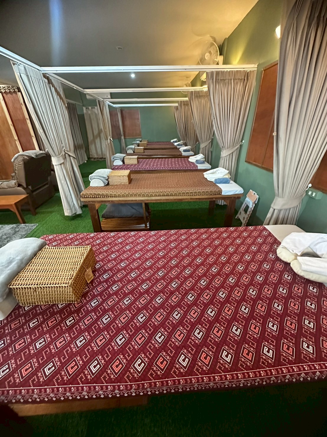 Interior massage room at Ketsirin Nai Thon with Thai-pattern treatment beds and privacy curtains