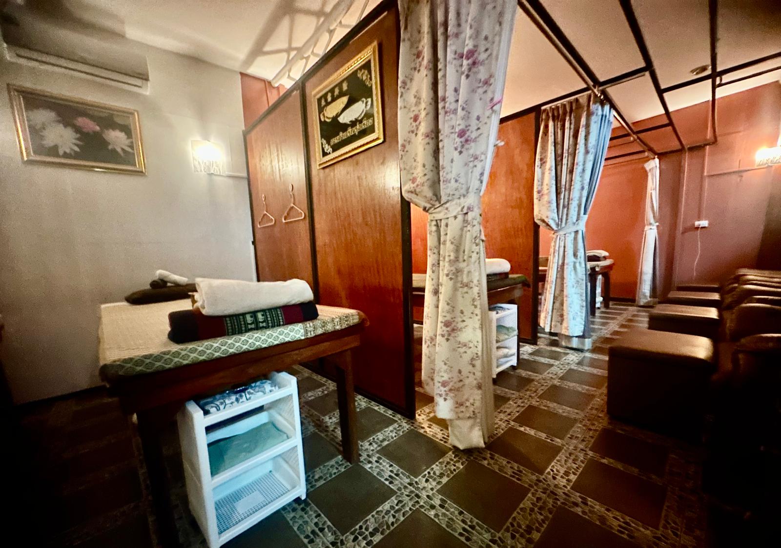 Thai massage treatment beds with traditional cushions and curtain dividers at Ketsirin Bang Tao